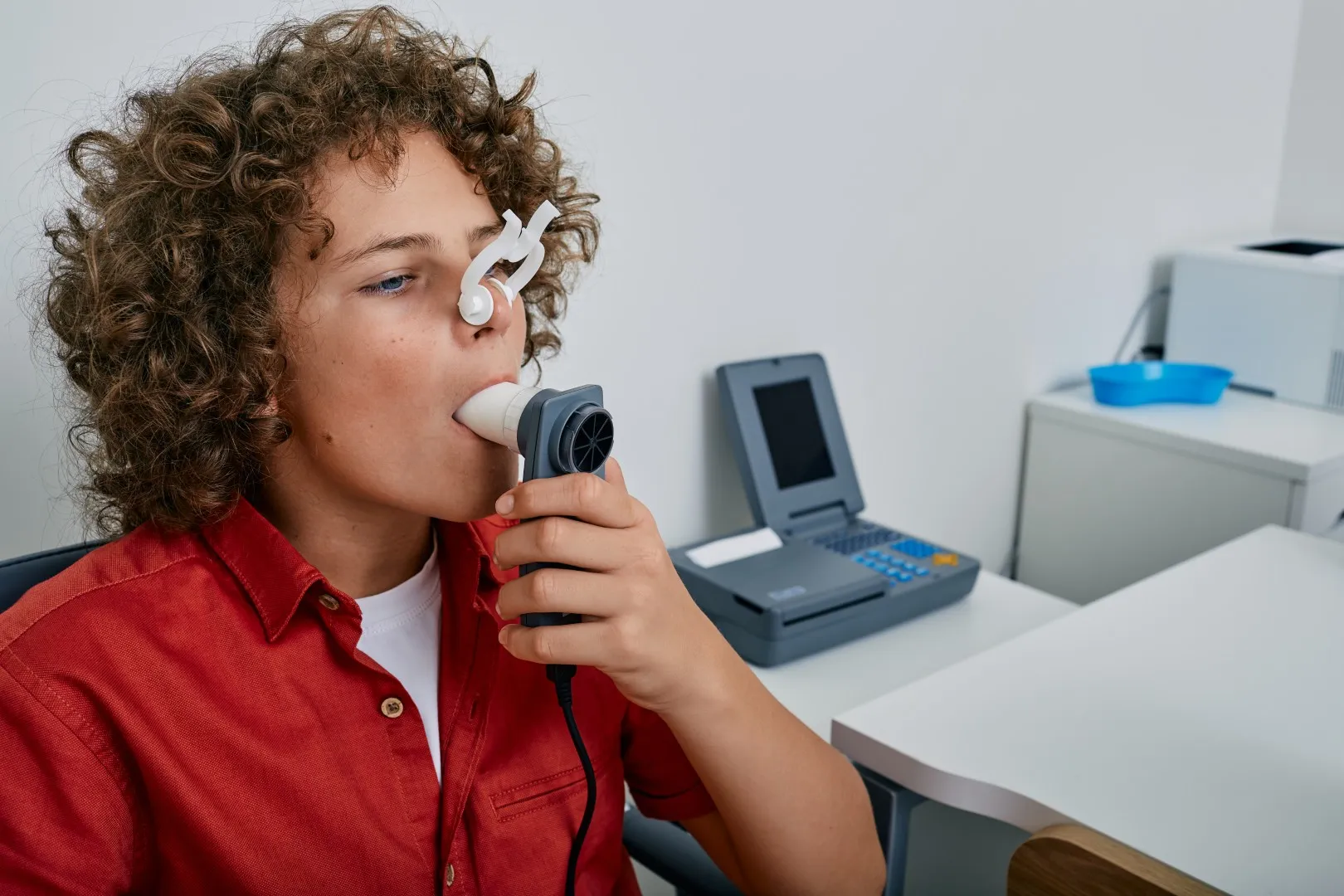 A boy performing a spirometry test at the clinic